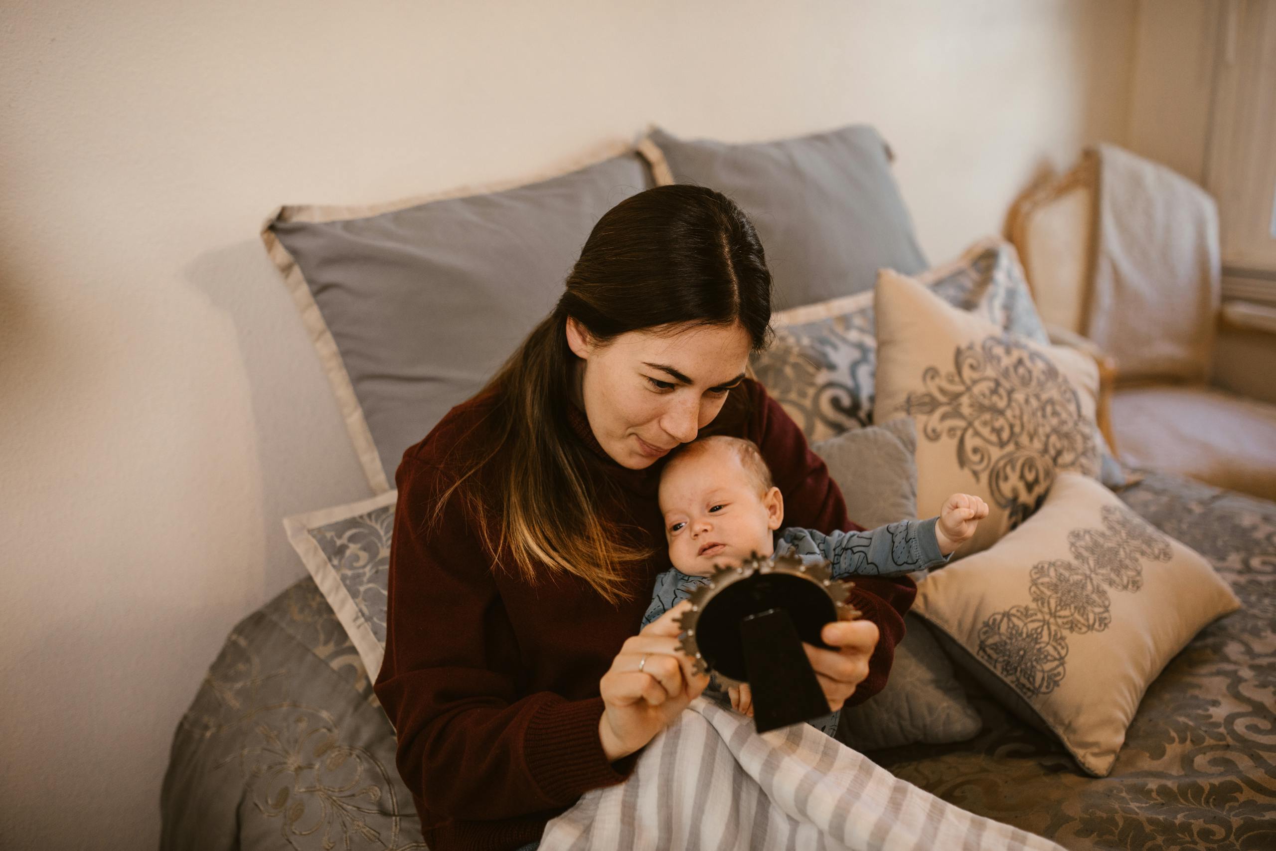 Mother and baby bonding in a warm, cozy bedroom, symbolizing love and parenthood.